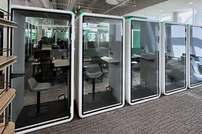 Soundproof office booth in use on a working office floor