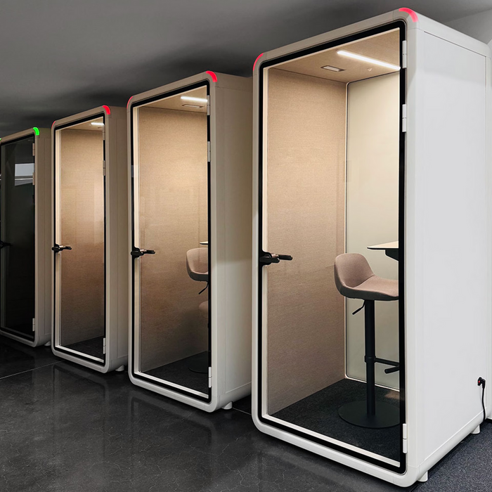 Acoustic booths beside desks in a shared workspace